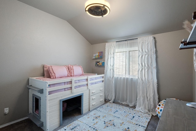 bedroom with lofted ceiling and dark colored carpet