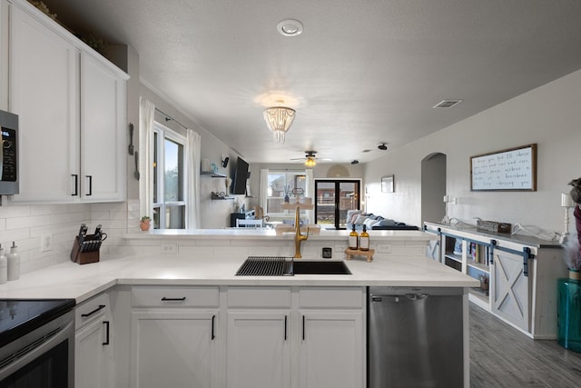 kitchen featuring stainless steel appliances, sink, white cabinets, and kitchen peninsula