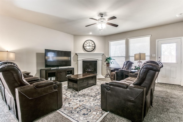 living area with carpet floors, a ceiling fan, and a glass covered fireplace