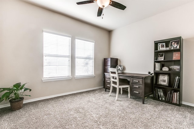 carpeted office space with baseboards and a ceiling fan