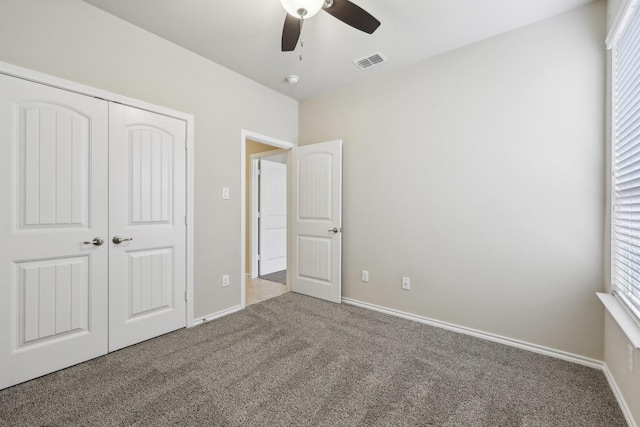 unfurnished bedroom featuring carpet floors, baseboards, visible vents, and a closet