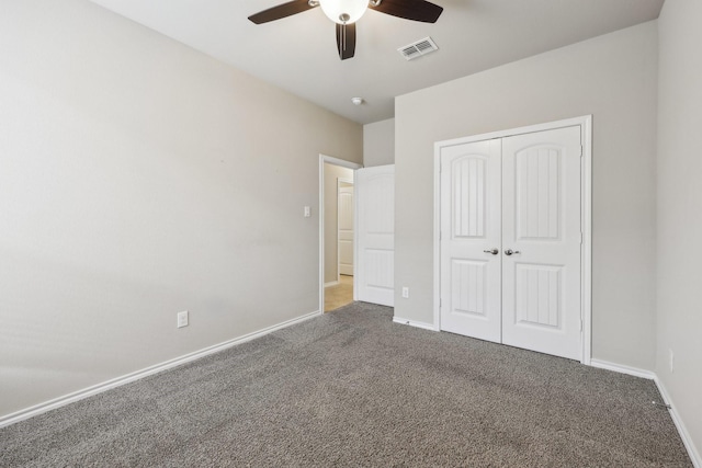 unfurnished bedroom with a closet, visible vents, carpet flooring, ceiling fan, and baseboards