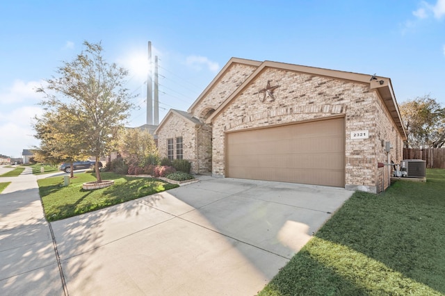 french provincial home with central air condition unit, a garage, brick siding, driveway, and a front lawn