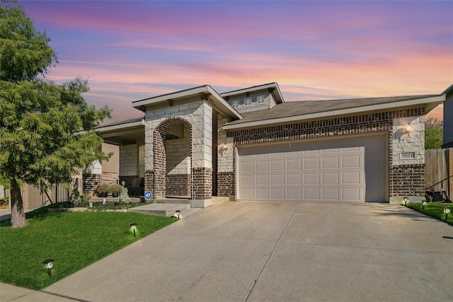 view of front of property featuring a garage and a lawn