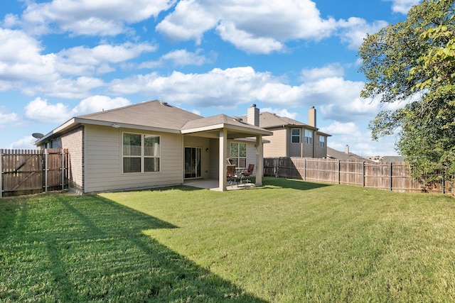 rear view of house featuring a patio area and a lawn