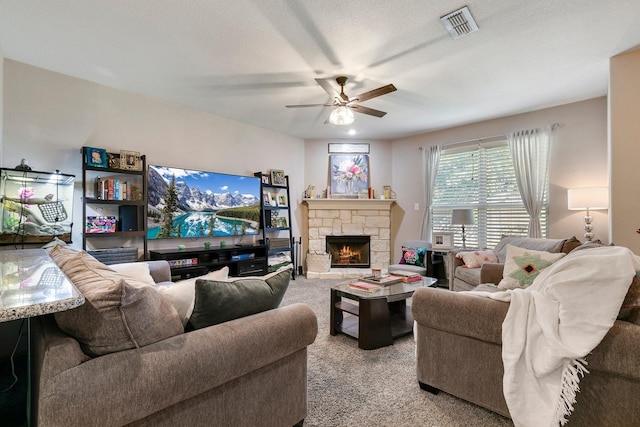 carpeted living room featuring ceiling fan and a fireplace