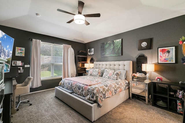 bedroom featuring ceiling fan, lofted ceiling, carpet flooring, and a tray ceiling