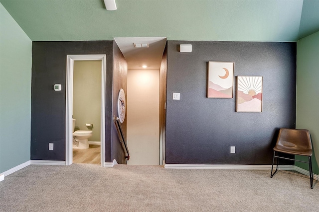 interior space featuring connected bathroom and carpet flooring