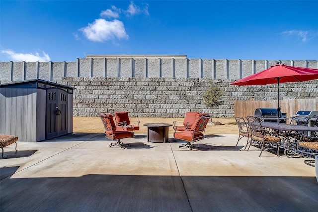 view of patio with a storage shed and an outdoor fire pit