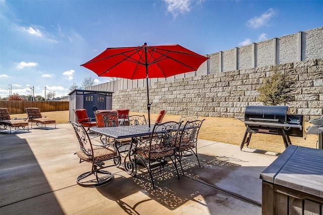 view of patio with area for grilling and a storage unit