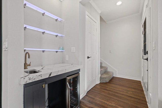 bar featuring wine cooler, sink, light stone counters, ornamental molding, and dark hardwood / wood-style floors