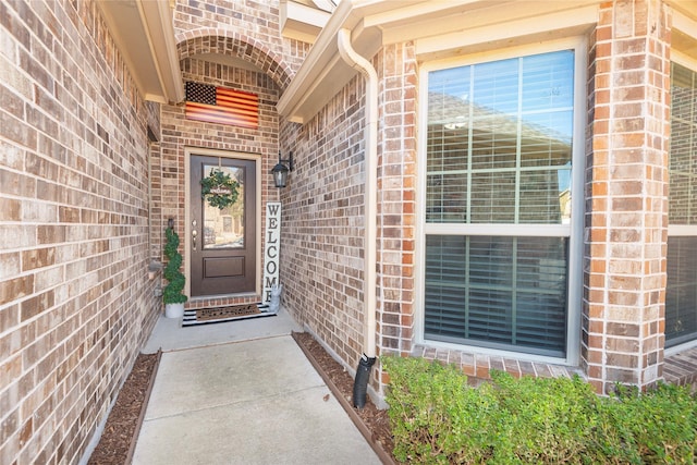 doorway to property with brick siding