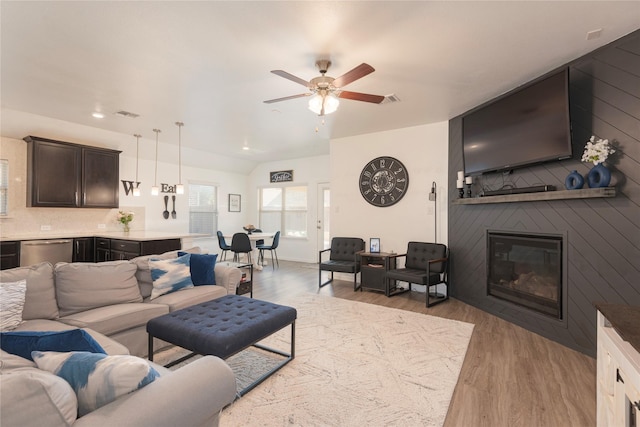 living room featuring visible vents, a ceiling fan, recessed lighting, a fireplace, and light wood finished floors