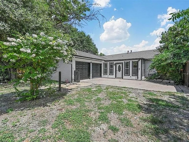 rear view of house featuring a garage and a patio