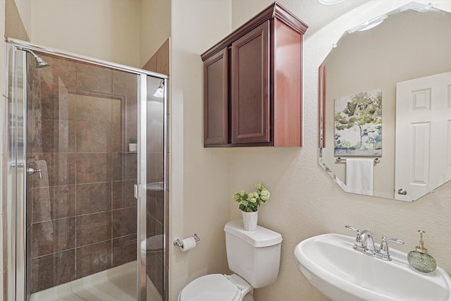 bathroom featuring sink, toilet, and an enclosed shower