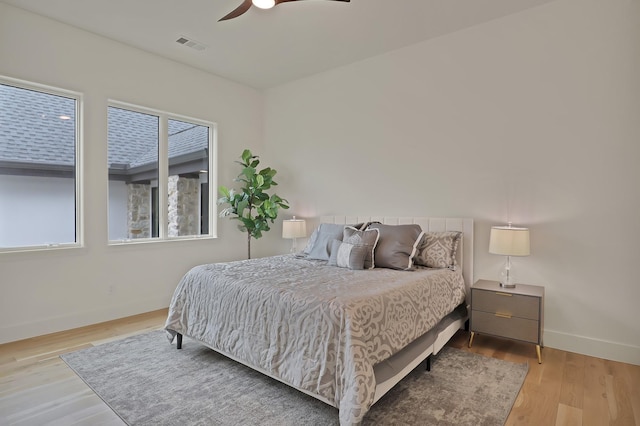 bedroom featuring multiple windows, light wood-type flooring, and ceiling fan