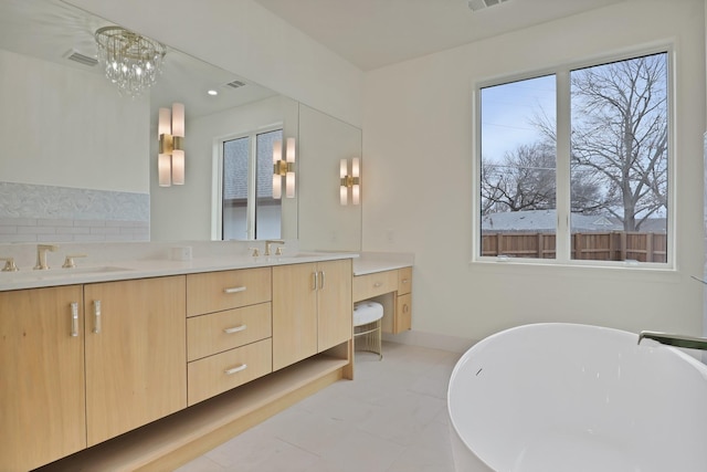 bathroom featuring a bathing tub, vanity, and tile patterned floors