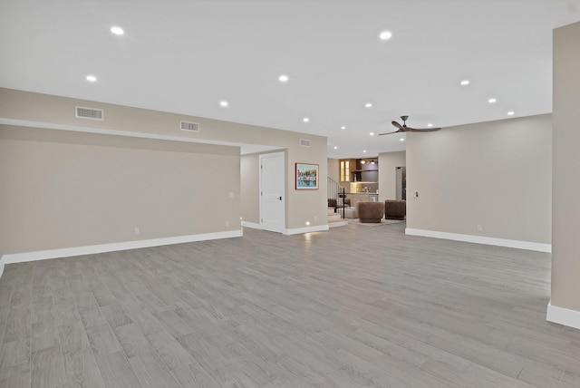 unfurnished living room featuring ceiling fan and light hardwood / wood-style floors