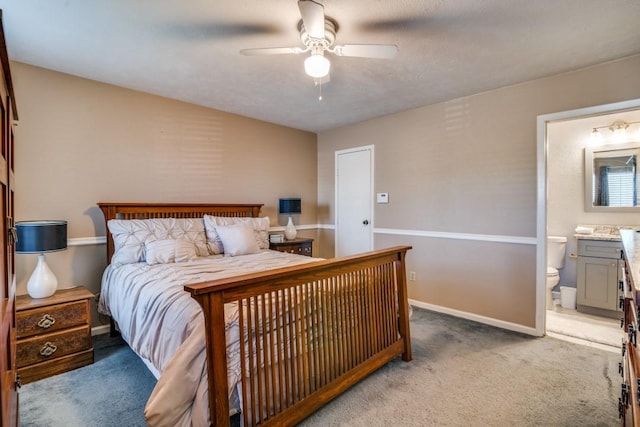 carpeted bedroom with ceiling fan and ensuite bath