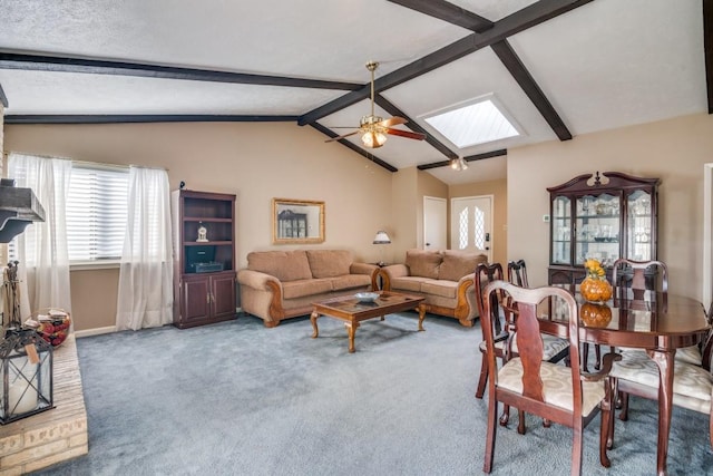 carpeted living room with lofted ceiling with skylight and ceiling fan