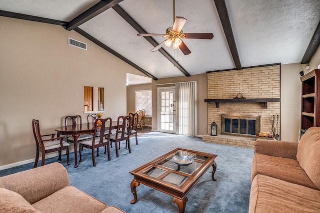 living room featuring a textured ceiling, carpet flooring, beamed ceiling, ceiling fan, and a fireplace