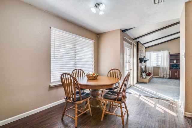 dining area with dark hardwood / wood-style flooring and lofted ceiling with beams