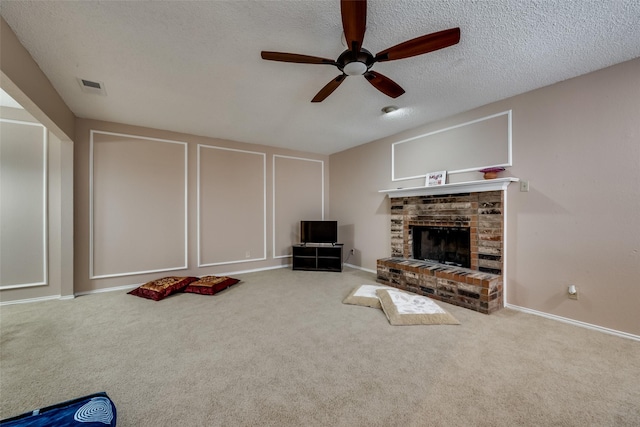 carpeted living room featuring ceiling fan, a brick fireplace, and a textured ceiling