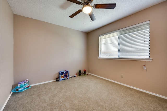 empty room featuring light carpet, ceiling fan, and a textured ceiling