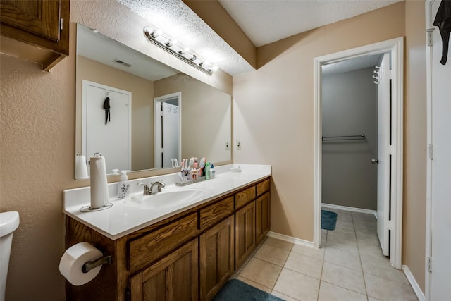 bathroom with vanity, tile patterned flooring, and a textured ceiling