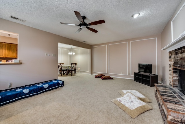 interior space with ceiling fan, a fireplace, carpet, and a textured ceiling