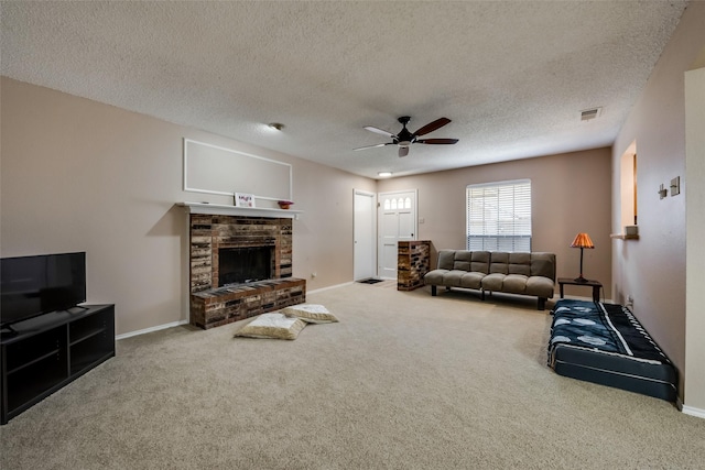 carpeted living room with ceiling fan, a brick fireplace, and a textured ceiling