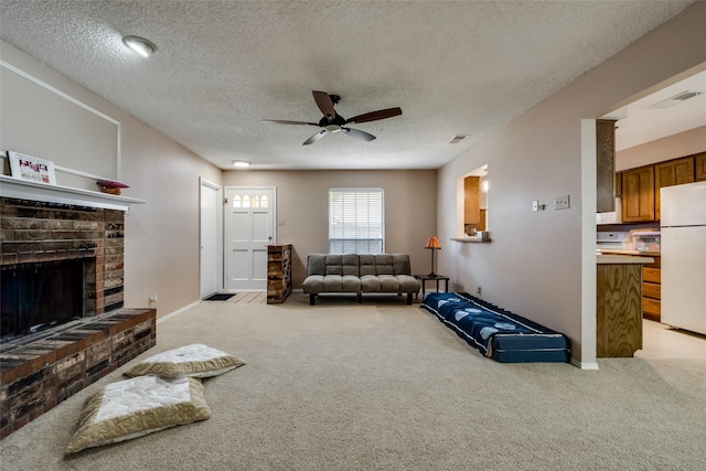 carpeted living room featuring a brick fireplace, a textured ceiling, and ceiling fan