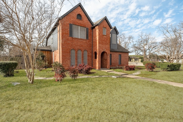 view of front of home with brick siding, roof with shingles, and a front yard