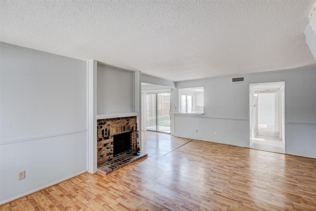 unfurnished living room with a textured ceiling and light wood-type flooring