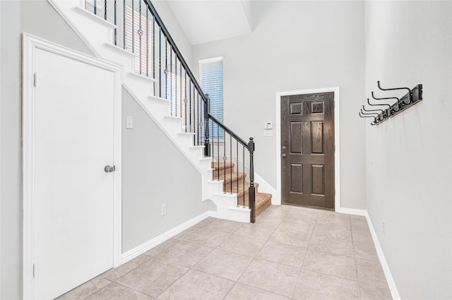 tiled foyer featuring a towering ceiling