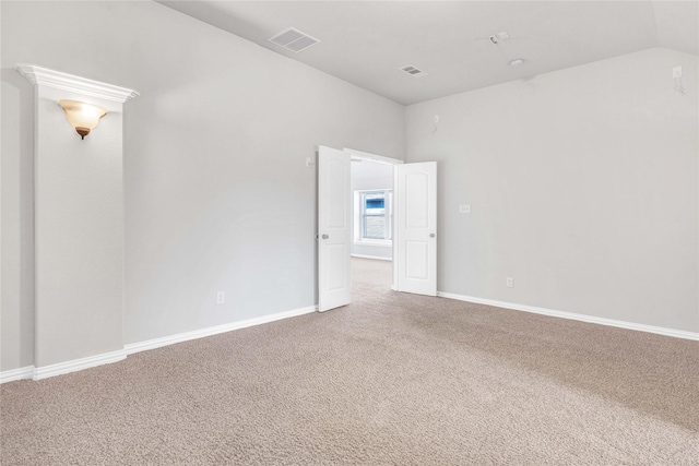 carpeted spare room featuring lofted ceiling