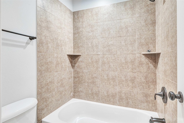 bathroom featuring toilet and tiled shower / bath combo