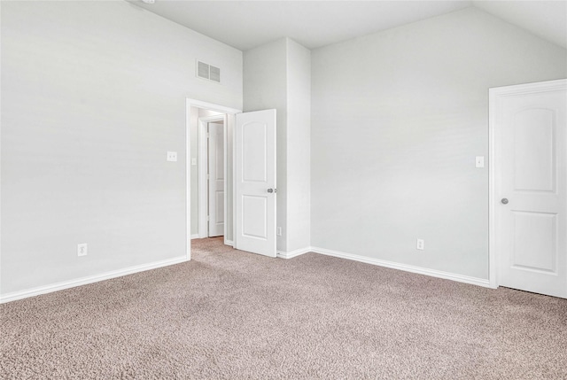 spare room featuring vaulted ceiling and carpet floors