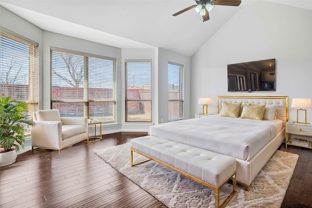 bedroom with ceiling fan, dark hardwood / wood-style floors, vaulted ceiling, and multiple windows