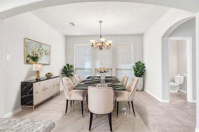 dining area featuring a healthy amount of sunlight and a chandelier