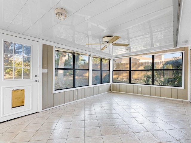 unfurnished sunroom with ceiling fan and a healthy amount of sunlight