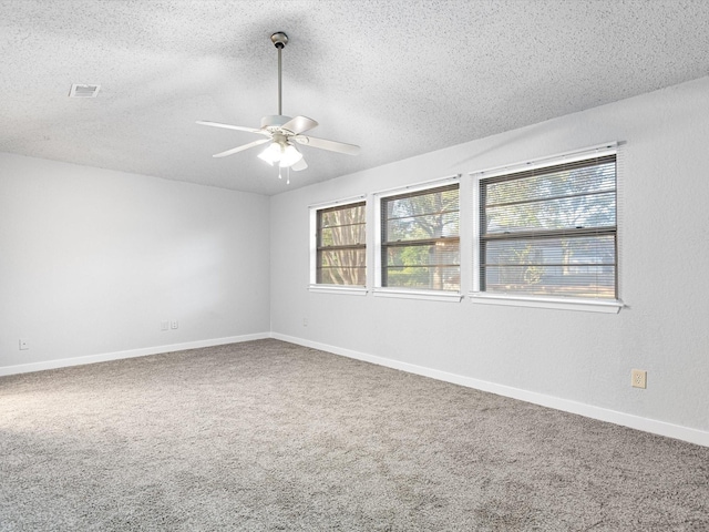 spare room with ceiling fan, carpet, and a textured ceiling