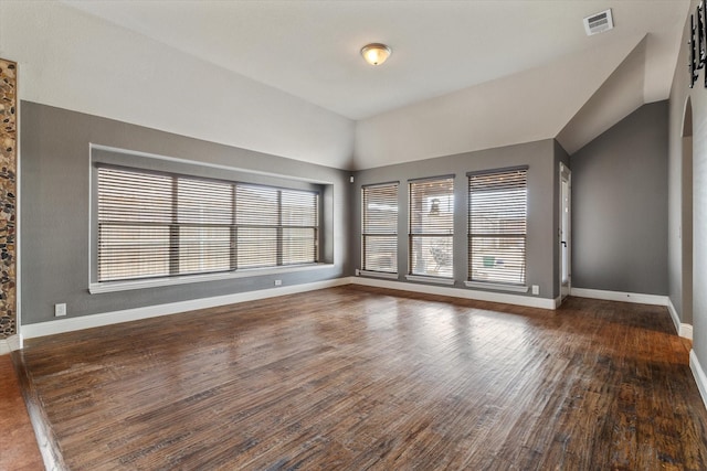 empty room with vaulted ceiling and dark wood-type flooring