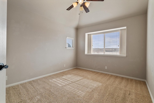 carpeted spare room featuring vaulted ceiling and ceiling fan