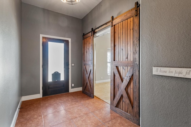 foyer with light tile patterned floors and a barn door