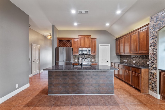 kitchen featuring decorative backsplash, stainless steel appliances, sink, and a center island with sink