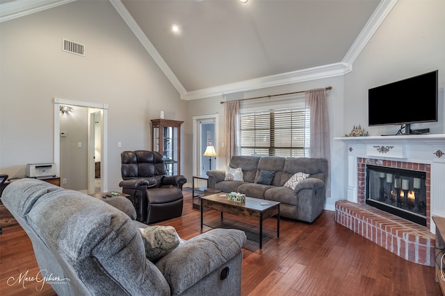 living room with a brick fireplace, dark wood-type flooring, high vaulted ceiling, and ornamental molding