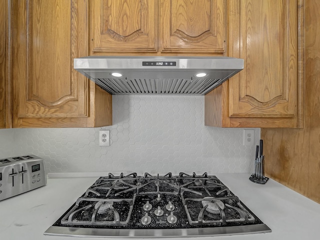 kitchen featuring backsplash, gas cooktop, and exhaust hood