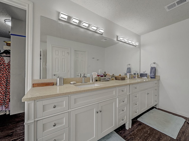 bathroom with vanity, hardwood / wood-style flooring, and a textured ceiling