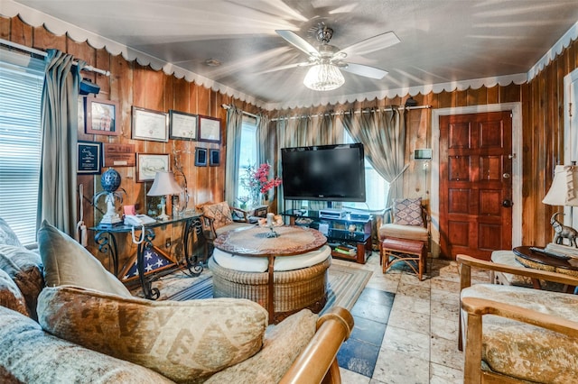 living room with ceiling fan and wooden walls